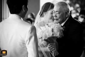 Four Seasons Bangkok wedding image. Bride, Daddy's Girl, embraces her father at the altar. Shot in black and white over the groom's shoulder.